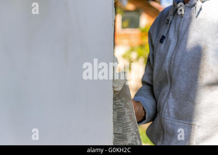 applying putty to the polyfoam wall Stock Photo