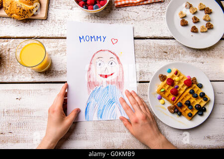 Childs drawing of her mom. Mothers day. Breakfast meal. Stock Photo