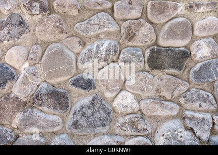 Gray pebble stones in a stone wall