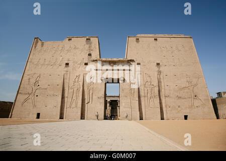 high wall front facade of Egyptian Edfu Temple of falcon god Horus, with carving figures and hieroglyphs, in Egypt, Africa Stock Photo