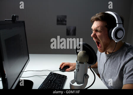 man in headset playing computer video game at home Stock Photo