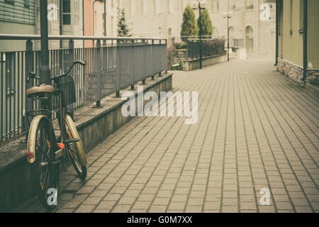 Urban scene with retro bike on empty street, vintage toned image Stock Photo