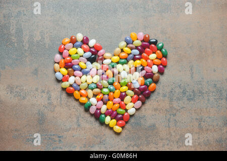 Heart symbol from jelly beans on dark background, love concept Stock Photo