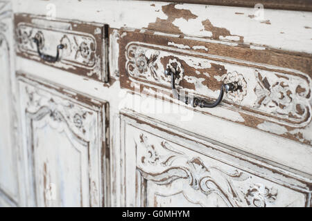 Close-up of ancient white commode bureau furniture with paint peeled off Stock Photo