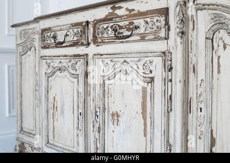 Close-up of ancient white commode bureau furniture with paint peeled off Stock Photo