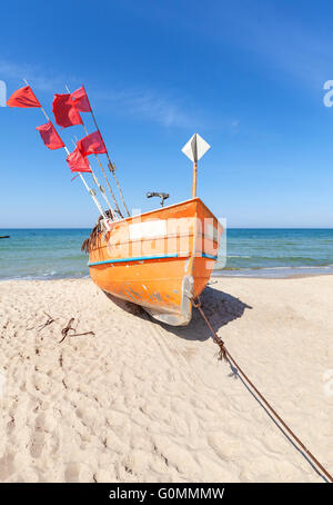Small fishing boat on a beach in Rewal, Poland. Stock Photo