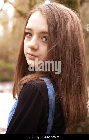 Pretty teenage girl looking over shoulder in an outdoor setting Stock Photo