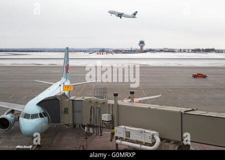 Air Canada jet at gate and one plane taking off, Ottawa Macdonald-Cartier International Airport. Stock Photo