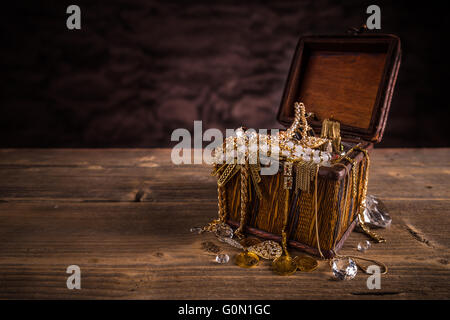 Treasure chest with jewellery on wooden background Stock Photo