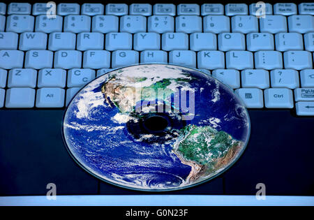 Earth are reflected in the CD on the notebook keyboard. Stock Photo