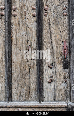 Weathered wooden door background with a metallic rusty rivets and screws. Stock Photo