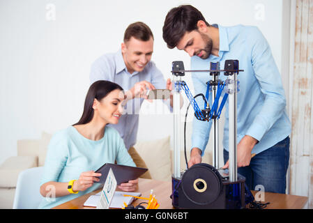 Handsome students using  3d printer. Stock Photo