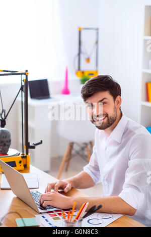 Handsome smiling man using laptop Stock Photo