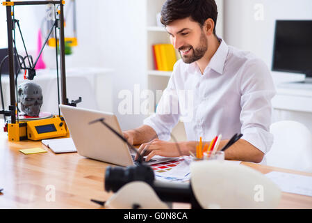 Handsome smiling man using laptop Stock Photo