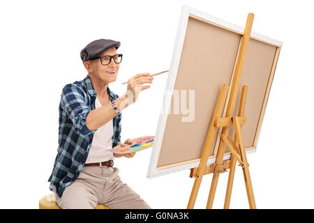 Senior artist painting on a canvas with a paintbrush isolated on white background Stock Photo