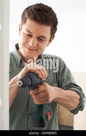 Young Man Using Electric Drill In House Renovation Project Stock Photo
