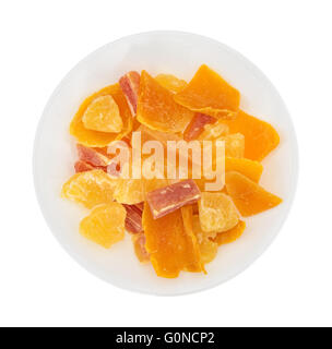 Top view of a serving of pineapple, mango and papaya sugared dried fruit on a plate isolated on a white background. Stock Photo