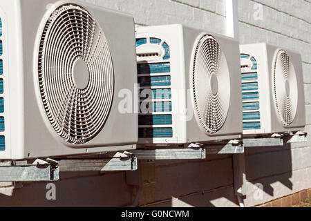 Newly installed air conditioning units mounted on brick exterior wall Stock Photo