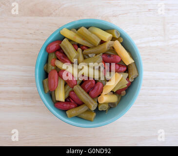Top view of three bean salad in a small bowl atop a wood table top. Stock Photo