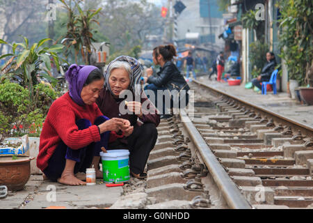 Hanoi, Vietnam - February 19, 2016: Old women eating on the railway in the center of Hanoi Stock Photo