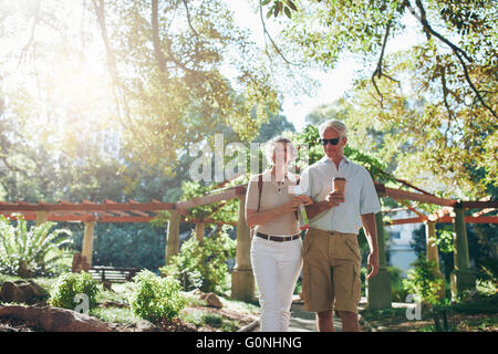 Portrait of couple of senior tourist walking through a park on a summer day. mature couple on a vacation. Stock Photo
