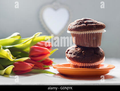 Two chocolate chip muffins and tulips Stock Photo