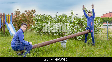 multiplicity photo, boy plays with himself on a seesaw Stock Photo