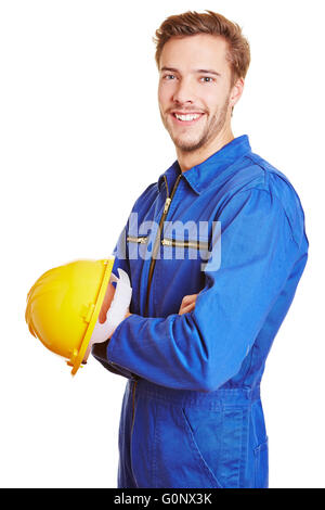 Happy smiling construction worker with yellow hardhat in blue overall Stock Photo