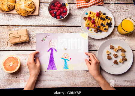 Childs drawing of her mom. Mothers day. Breakfast meal. Stock Photo