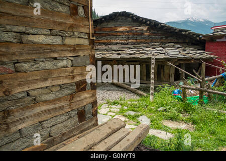 A beautiful Himalayan Log House in the traditional style with alternating layers of wood and stone Stock Photo