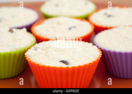 Cooking cheese and vanilla syrniki as cupcakes or muffins, in colored muffins cups closeup. Stock Photo