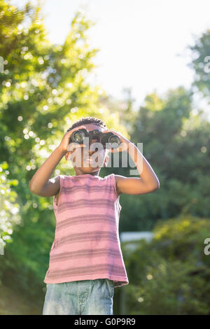 Boy looking through binoculars Stock Photo