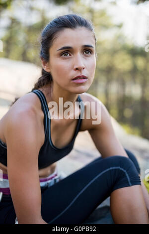 Portrait of woman looking up with climbing equipment Stock Photo