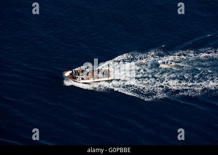 Tourist boat with tourists towing a small dinghy in the Bay of Naples, Capri, Campania,Italy, Europe Stock Photo