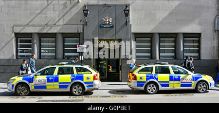 Police station UK public entrance & blue lamps Bishopsgate City of London England & police cars parked outside with unconnected passers-by on pavement Stock Photo