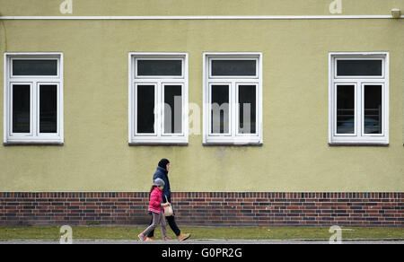 Bad Fallingbostel, Germany. 30th Mar, 2016. A woman and child walk through the refugee accommodation in Camp Bad Fallingbostel West in Bad Fallingbostel, Germany, 30 March 2016. Around 200 people are currently being housed in Camp West. Photo: HOLGER HOLLEMANN/dpa/Alamy Live News Stock Photo