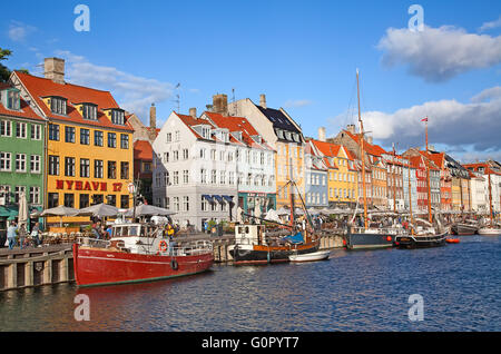 COPENHAGEN, DENMARK - AUGUST 25: unidentified people enjoying sunny weather in open cafees of the famous Nyhavn promenade on Aug Stock Photo