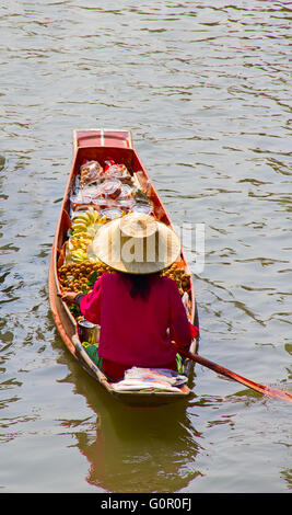 RATCHABURI, THAILAND - FEB 20: A woman serves Thai food at Damnoen Saduak floating market on February 20, 2011 in Ratchaburi, Th Stock Photo