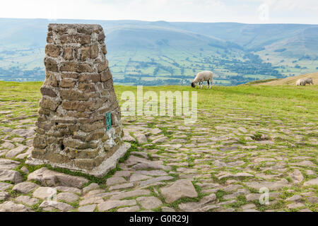 The trig point or triangulation pillar on the summit of Mam Tor with Kinder Scout in the distance, Derbyshire, England, UK Stock Photo