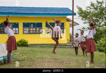 JAYAPURA, WEST PAPUA, INDONESIA - CIRCA FEBRUARY 2016: Schoolkids playing outside the schoolhouse during a break Stock Photo