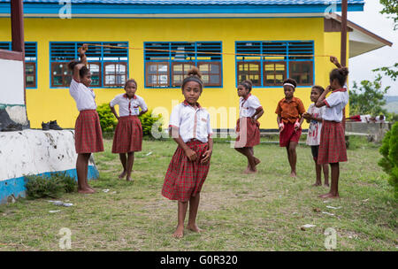 JAYAPURA, WEST PAPUA, INDONESIA - CIRCA FEBRUARY 2016: Schoolkids playig outside the schoolhouse during a break Stock Photo