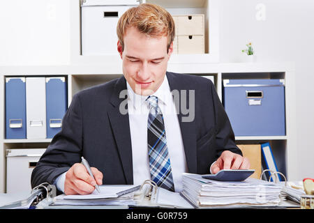 Accountant doing financing in the office with a calculator for a tax audit Stock Photo