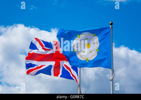 The United Kingdom flag and the official Yorkshire Flag of a white rose on a blue ground flying side by side. Stock Photo