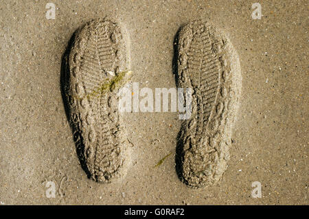 Prints of shoe soles in the sand Stock Photo