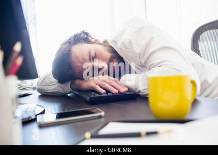A man sleeping on his desk Stock Photo