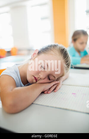 A cute girl falling asleep at desk Stock Photo