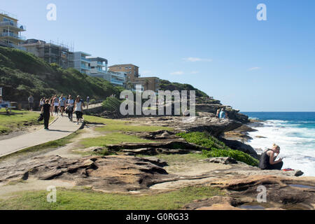 People walking along Sydney's Coastal Walk at Tamarama overlooking the pacific Ocean. Stock Photo