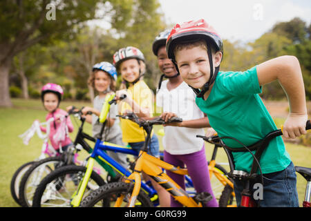 Smiling children posing in raw with bikes Stock Photo