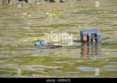 Plastic waste floating down a river causing pollution in a river in Bangkok, Thailand. Stock Photo