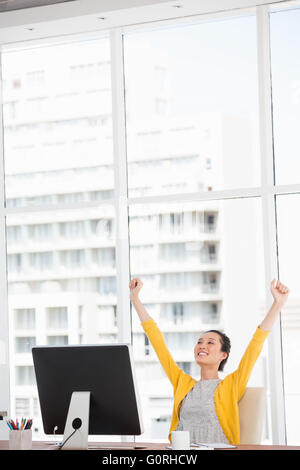 A cheerful woman at her desk Stock Photo